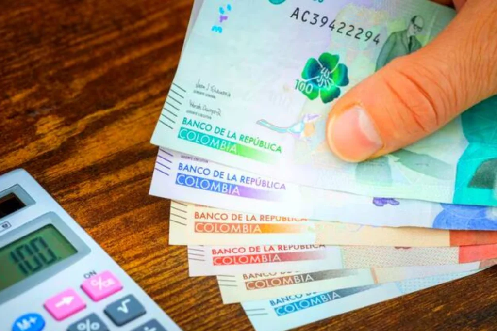 Declaración de renta: vender una casa o un carro puede cambiar sus obligaciones ante la DIAN Manos de una persona sosteniendo billetes