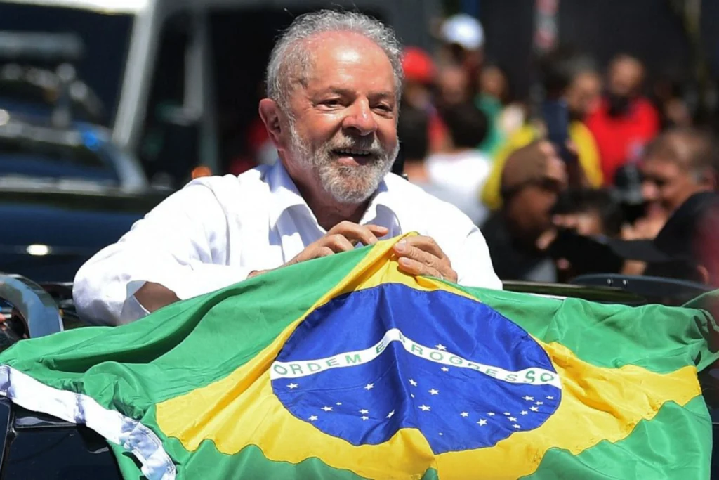 Lula festejando su victoria detrás de una bandera de Brasil