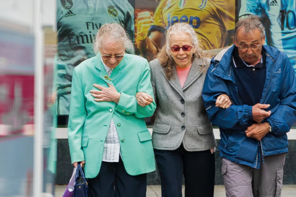 tres adultos mayores caminando tomados del brazo