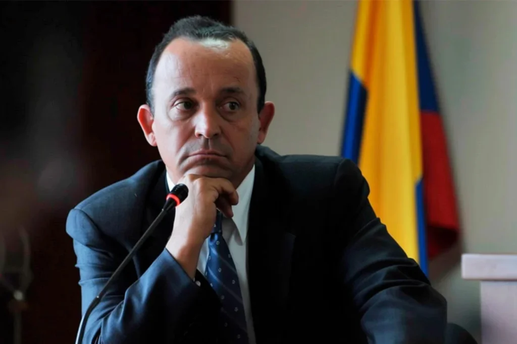 Santiago Uribe con la bandera de Colombia detrás
